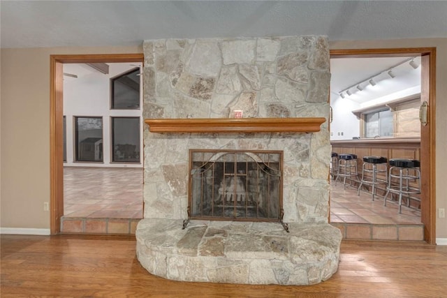 interior details featuring hardwood / wood-style floors and a stone fireplace