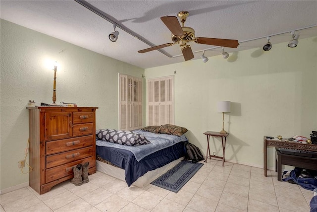 bedroom with track lighting, ceiling fan, and a textured ceiling