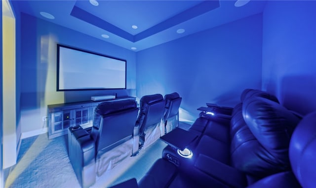 home theater room featuring a tray ceiling, recessed lighting, carpet, and baseboards