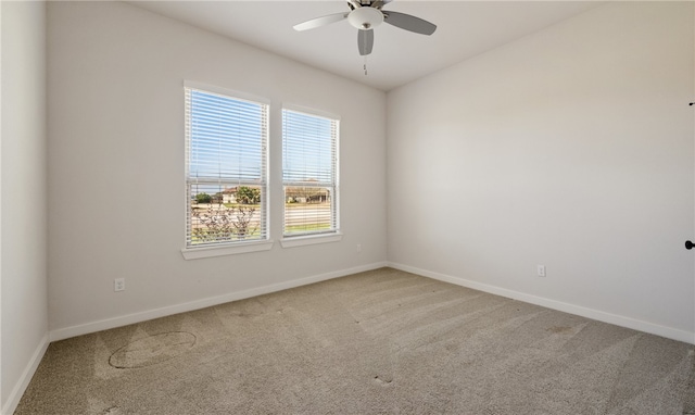 empty room featuring baseboards, light carpet, and ceiling fan