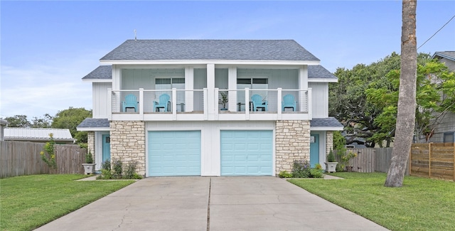 view of front facade with a garage, a front yard, and a balcony