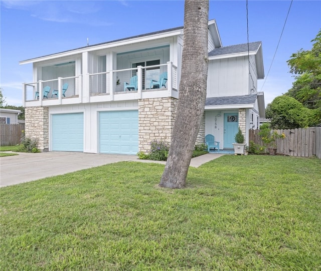 view of front of home featuring a garage, a front lawn, and a balcony