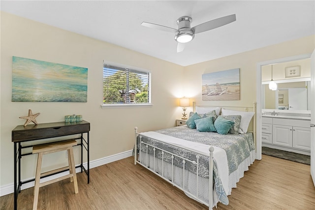 bedroom with light hardwood / wood-style flooring, ceiling fan, sink, and connected bathroom