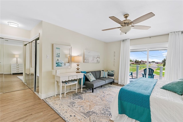 bedroom with access to outside, wood-type flooring, and ceiling fan