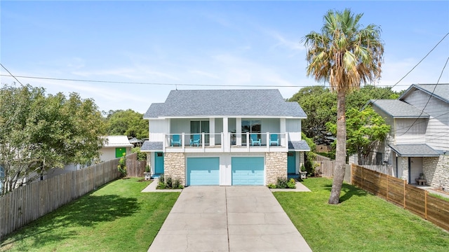 view of front of home with a garage, a front lawn, and a balcony