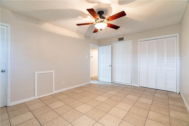 5905 Norvel Dr, Corpus Christi, TX 78412 - unfurnished bedroom featuring multiple closets, light tile patterned floors, and a ceiling fan