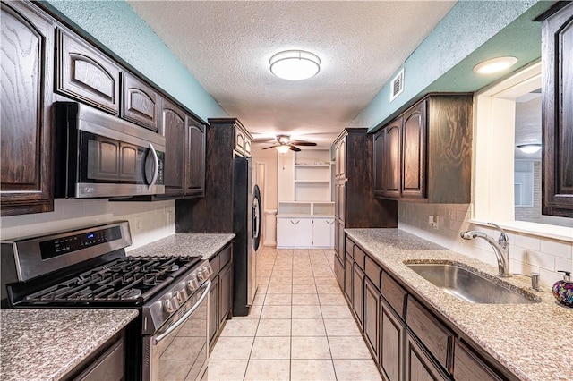 5905 Norvel Dr, Corpus Christi, TX 78412 - kitchen with appliances with stainless steel finishes, dark brown cabinetry, tasteful backsplash, light tile patterned flooring, and a textured ceiling
