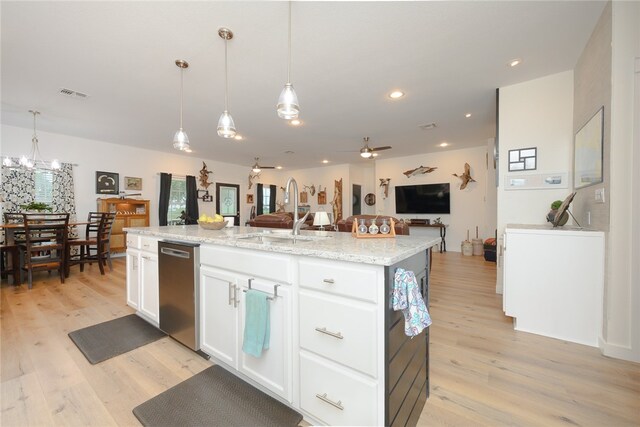 kitchen featuring a center island with sink, white cabinets, hanging light fixtures, sink, and light wood-type flooring