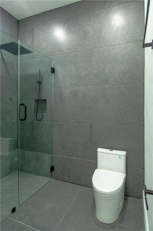 607 Matlock, Aransas Pass, TX 78336 - bathroom featuring a shower stall, toilet, and tile patterned floors
