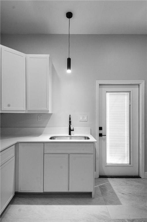 607 Matlock, Aransas Pass, TX 78336 - kitchen featuring a sink, white cabinetry, light countertops, and hanging light fixtures