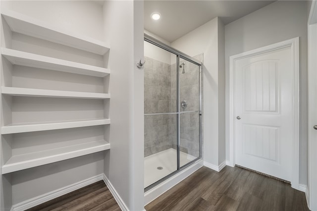 bathroom featuring a shower with shower door and hardwood / wood-style flooring