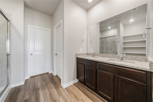 bathroom with vanity, hardwood / wood-style flooring, and a shower with door