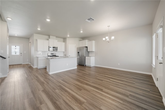 kitchen with pendant lighting, white cabinets, stainless steel appliances, and wood-type flooring