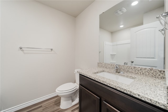 bathroom featuring vanity, hardwood / wood-style flooring, toilet, and walk in shower