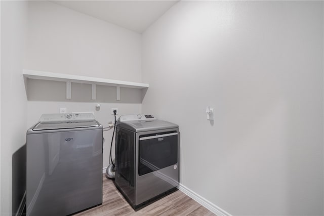 washroom featuring light wood-type flooring and washing machine and clothes dryer