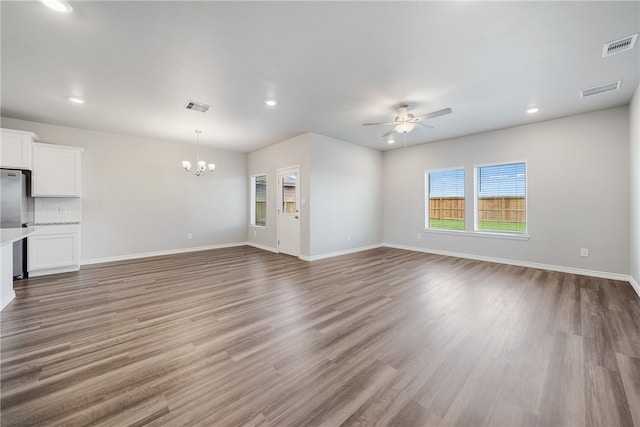 unfurnished living room with hardwood / wood-style floors and ceiling fan with notable chandelier