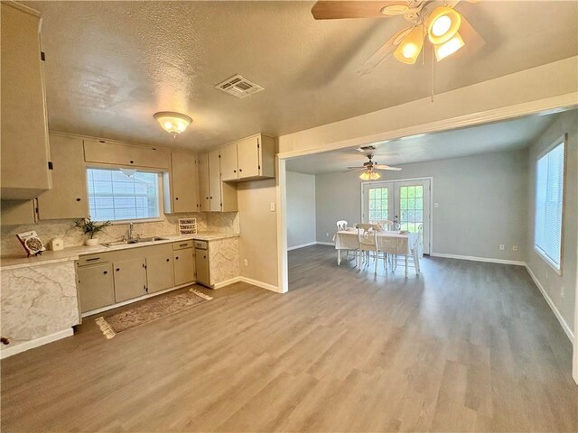 1230 Dona, Corpus Christi, TX 78407 - kitchen with light countertops, decorative backsplash, light wood-style flooring, ceiling fan, and a textured ceiling