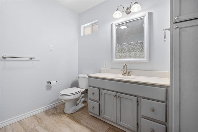 1003 S Pearl St, Rockport, TX 78382 - bathroom with toilet, vanity, wood finished floors, and baseboards