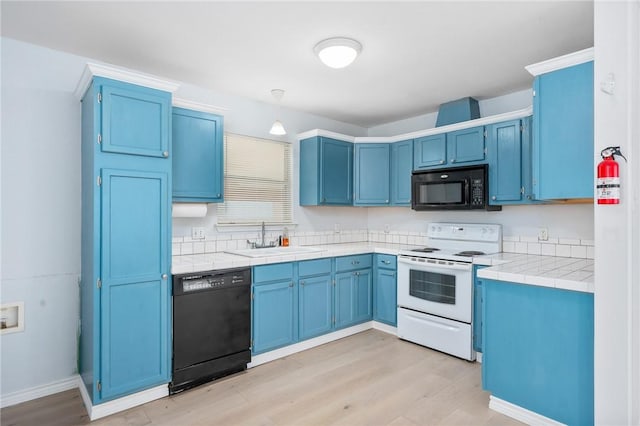 1003 S Pearl St, Rockport, TX 78382 - kitchen with black appliances, a sink, and blue cabinetry