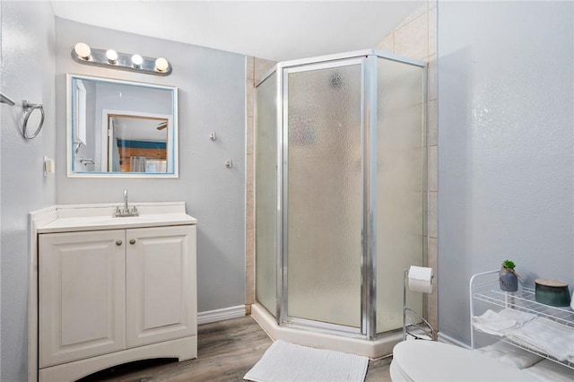 1003 S Pearl St, Rockport, TX 78382 - bathroom with a stall shower, wood finished floors, vanity, and toilet