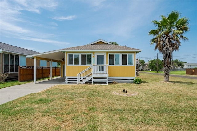 1003 S Pearl St, Rockport, TX 78382 - view of front of house with concrete driveway, an attached carport, entry steps, and roof with shingles