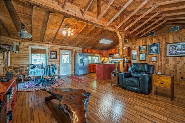 unfurnished living room with lofted ceiling with beams, wood walls, wood ceiling, and wood-type flooring