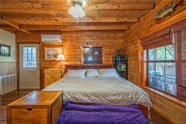 bedroom featuring an AC wall unit, dark wood-type flooring, multiple windows, and beamed ceiling