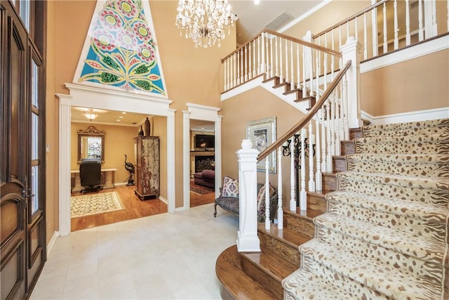 7001 Bevington Dr, Corpus Christi, TX 78413 - entryway with stairway, decorative columns, ornamental molding, a high ceiling, and a fireplace