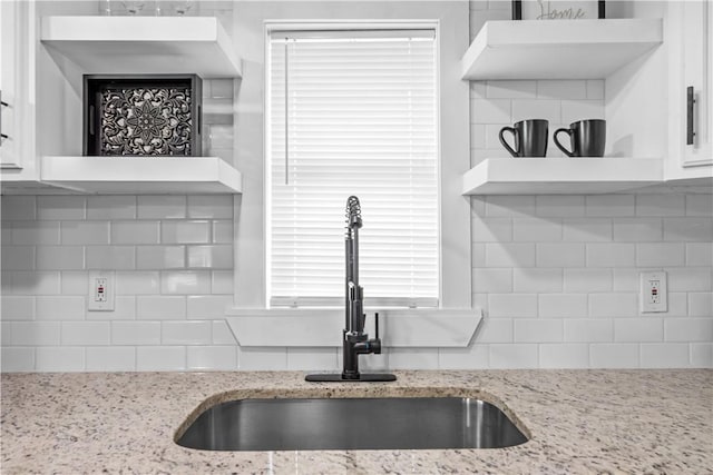 2845 Elgin St, Corpus Christi, TX 78405 - kitchen with white cabinetry, backsplash, light stone countertops, and open shelves