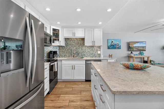 6649 Seacomber Dr Unit 807, Port Aransas, TX 78373 - kitchen with appliances with stainless steel finishes, light wood-style floors, white cabinetry, tasteful backsplash, and recessed lighting