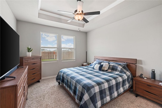 bedroom featuring a ceiling fan, baseboards, light colored carpet, and a raised ceiling