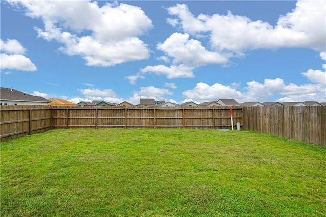 view of yard featuring a fenced backyard and a residential view