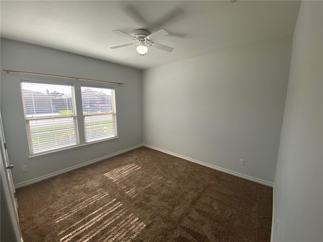 unfurnished room with ceiling fan and dark carpet