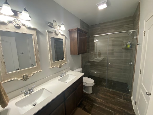 bathroom with hardwood / wood-style floors, vanity, toilet, and an enclosed shower