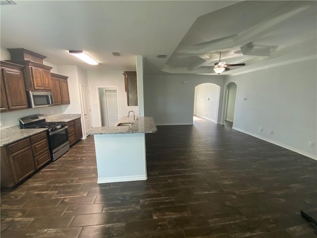 7618 Sable Creek Dr, Corpus Christi, TX 78414 - kitchen with appliances with stainless steel finishes, arched walkways, a sink, open floor plan, and light stone counters