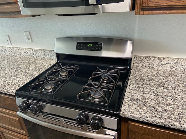 details featuring gas stove and light stone countertops