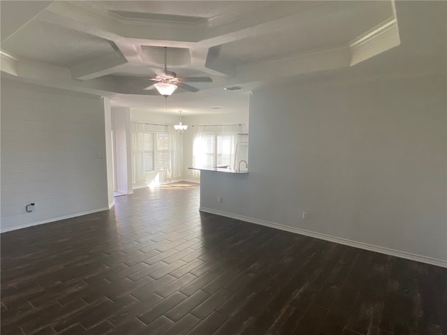 spare room featuring ceiling fan with notable chandelier, dark hardwood / wood-style floors, ornamental molding, and coffered ceiling