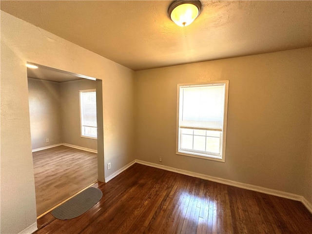 spare room with dark wood-type flooring