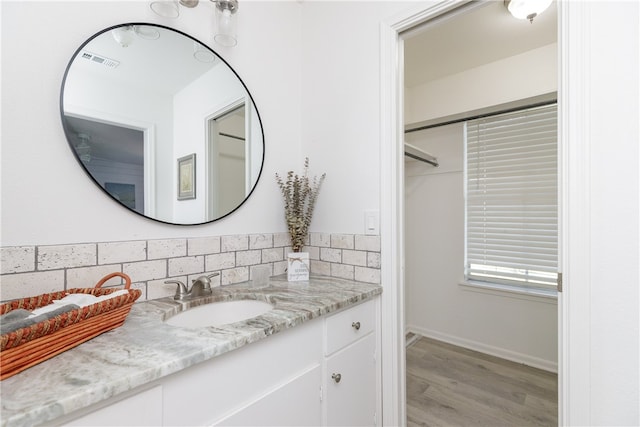 bathroom with decorative backsplash, vanity, and wood-type flooring