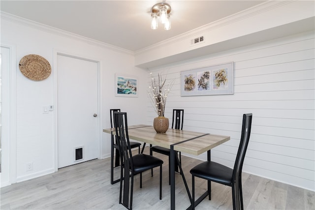 dining room featuring crown molding and light hardwood / wood-style flooring