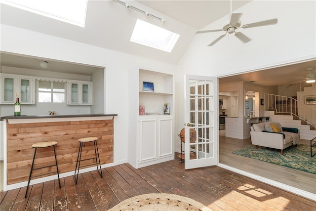 interior space with high vaulted ceiling, dark hardwood / wood-style flooring, rail lighting, and ceiling fan