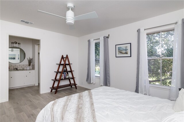 bedroom with light hardwood / wood-style floors, ceiling fan, and multiple windows