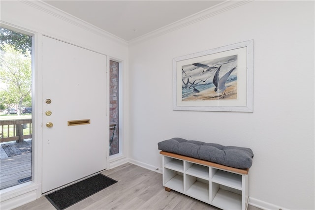 entrance foyer with light hardwood / wood-style flooring and crown molding