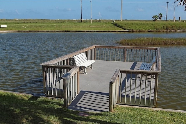 dock area with a yard and a water view