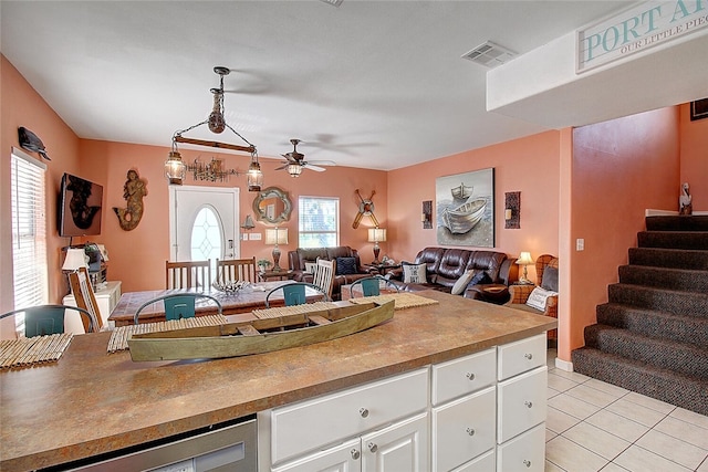 141 Mustang Royale Blvd, Port Aransas, TX 78373 - kitchen featuring open floor plan, a ceiling fan, light tile patterned floors, white cabinets, and dishwasher