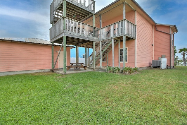 141 Mustang Royale Blvd, Port Aransas, TX 78373 - rear view of property featuring a deck, a patio, a yard, stairway, and central AC unit