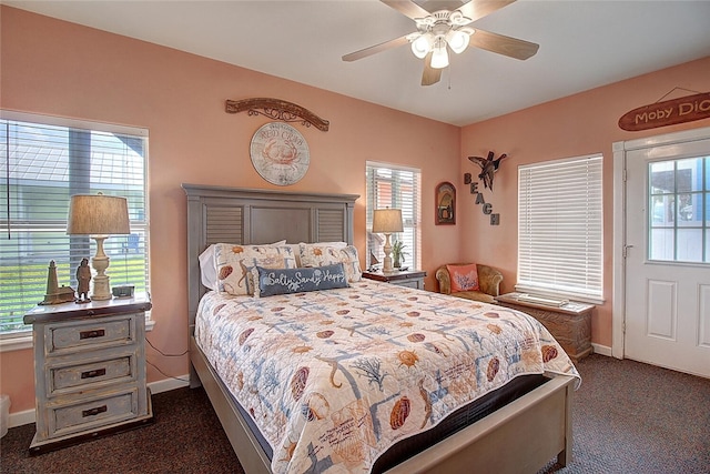 141 Mustang Royale Blvd, Port Aransas, TX 78373 - bedroom with dark carpet, baseboards, multiple windows, and ceiling fan
