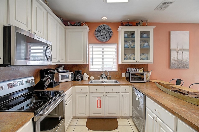 141 Mustang Royale Blvd, Port Aransas, TX 78373 - kitchen featuring appliances with stainless steel finishes, a sink, light tile patterned floors, white cabinetry, and recessed lighting