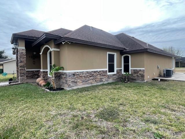 view of property exterior with central AC and a lawn