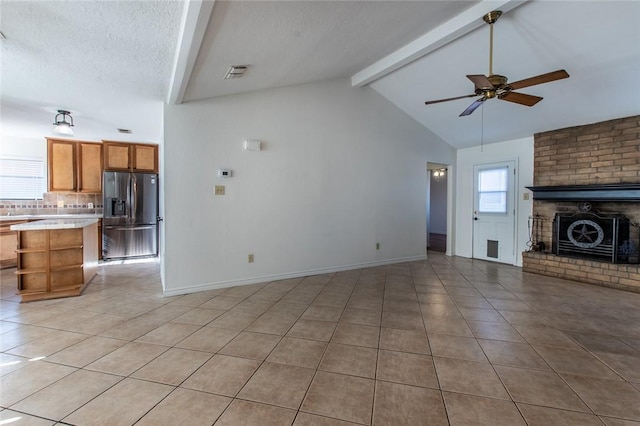 living room featuring lofted ceiling, light tile patterned floors, and ceiling fan